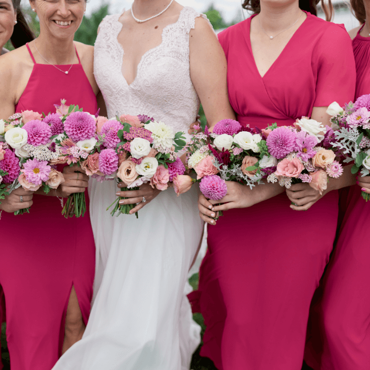 bride in white gown smiling down at her bouquet